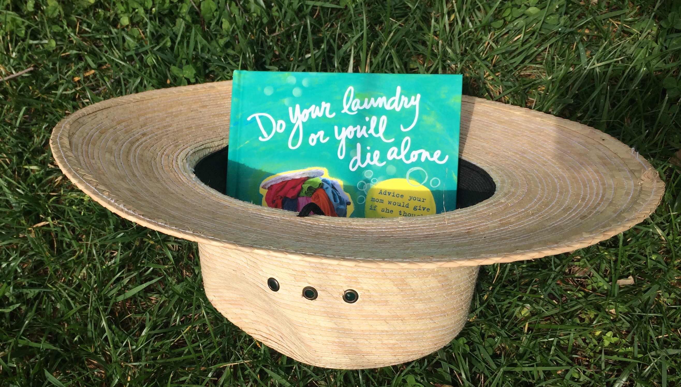 do your laundry or you'll die alone book in straw hat on grass